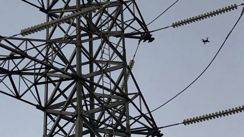 drone flying near electric utility tower